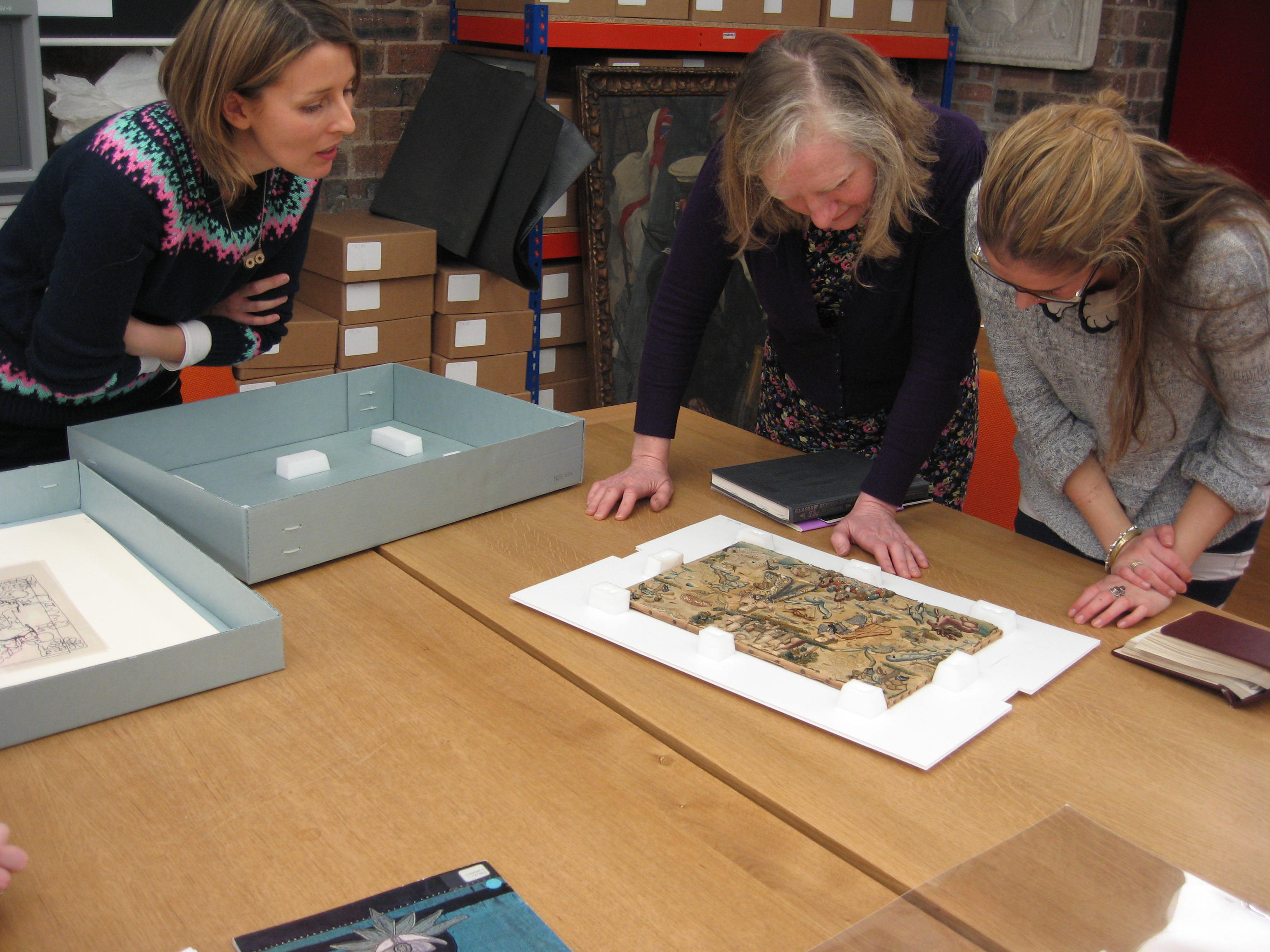 GSA's Archivist Susannah shows ECA researchers Lindy and Lucie some items from our Needlework Development Scheme textile collection. 
