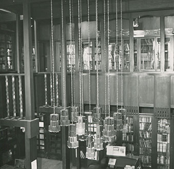 Photograph of the library on the first floor of the Mackintosh Building, taken from the gallery and showing ceiling lights in detail. (Archive Reference: GSAA/P/7/190)