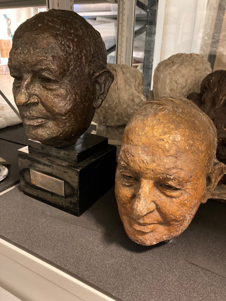 Plaster maquette and bronze bust of head side by side.
