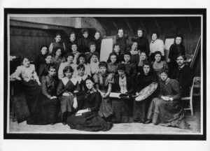 Black and white photograph of group of 31 women and one man, in art studio. Photogprah is from 1890s, with clothing appropriate for this era.