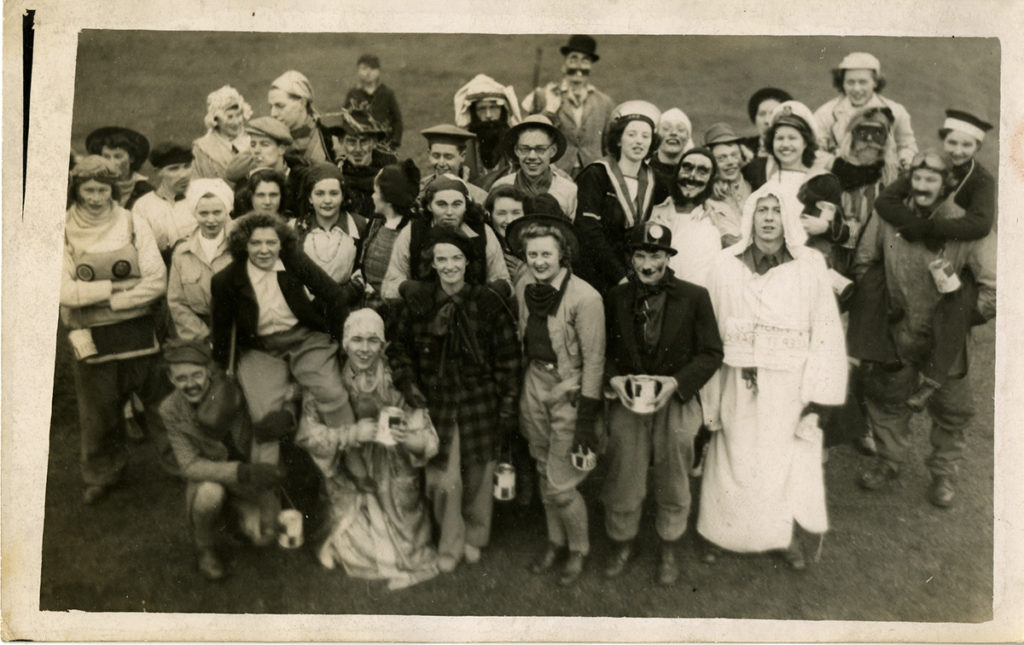 A group of students pose out of doors wearing fancy dress costumes